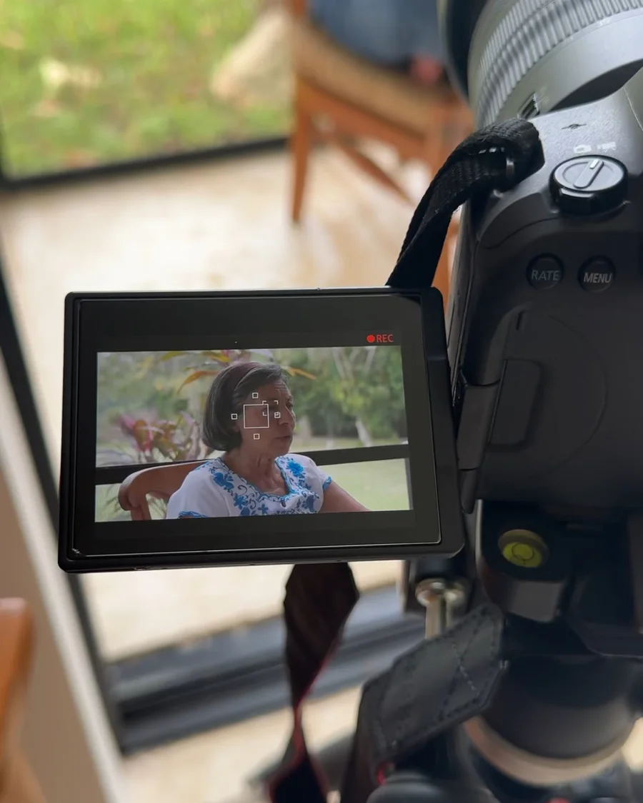 Camera on a tripod recording an interview, the subject shown on the flip screen